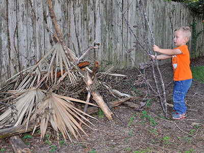 child with brush pile